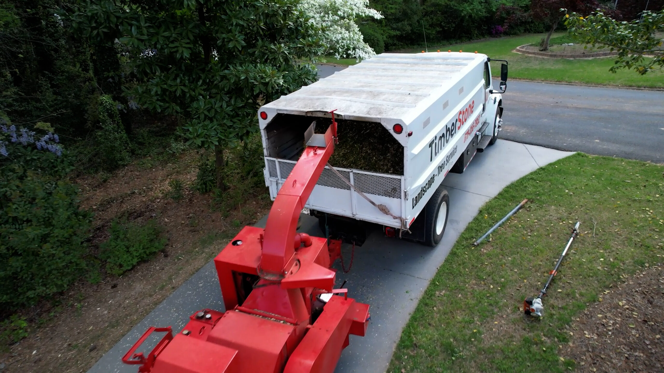 Aerial looking down on the chipper discharging into the branded Timberstone truck bed